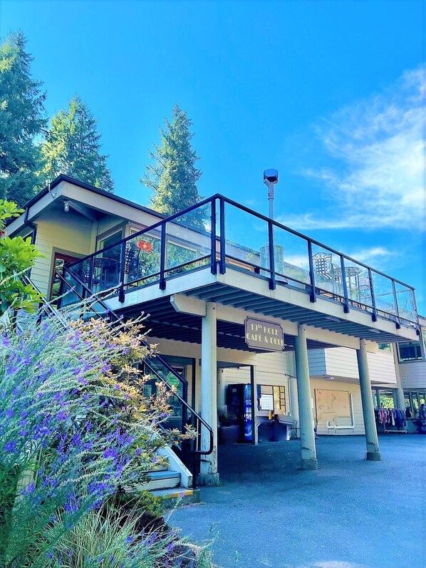 A building with a sign reading "19th Hole Café & Deli" and an outdoor seating area.