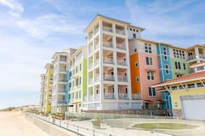 Ein mehrstöckiges Hotel mit Balkonen in Strandnähe.
