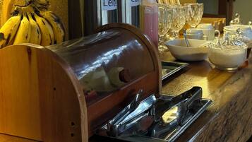 A kitchen counter with a coffee machine, a fruit bowl, and various kitchen utensils.