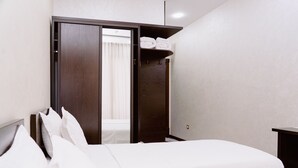 A hotel room with a bed, a wardrobe, and a small table. - PGA Hotel (Tashkent)