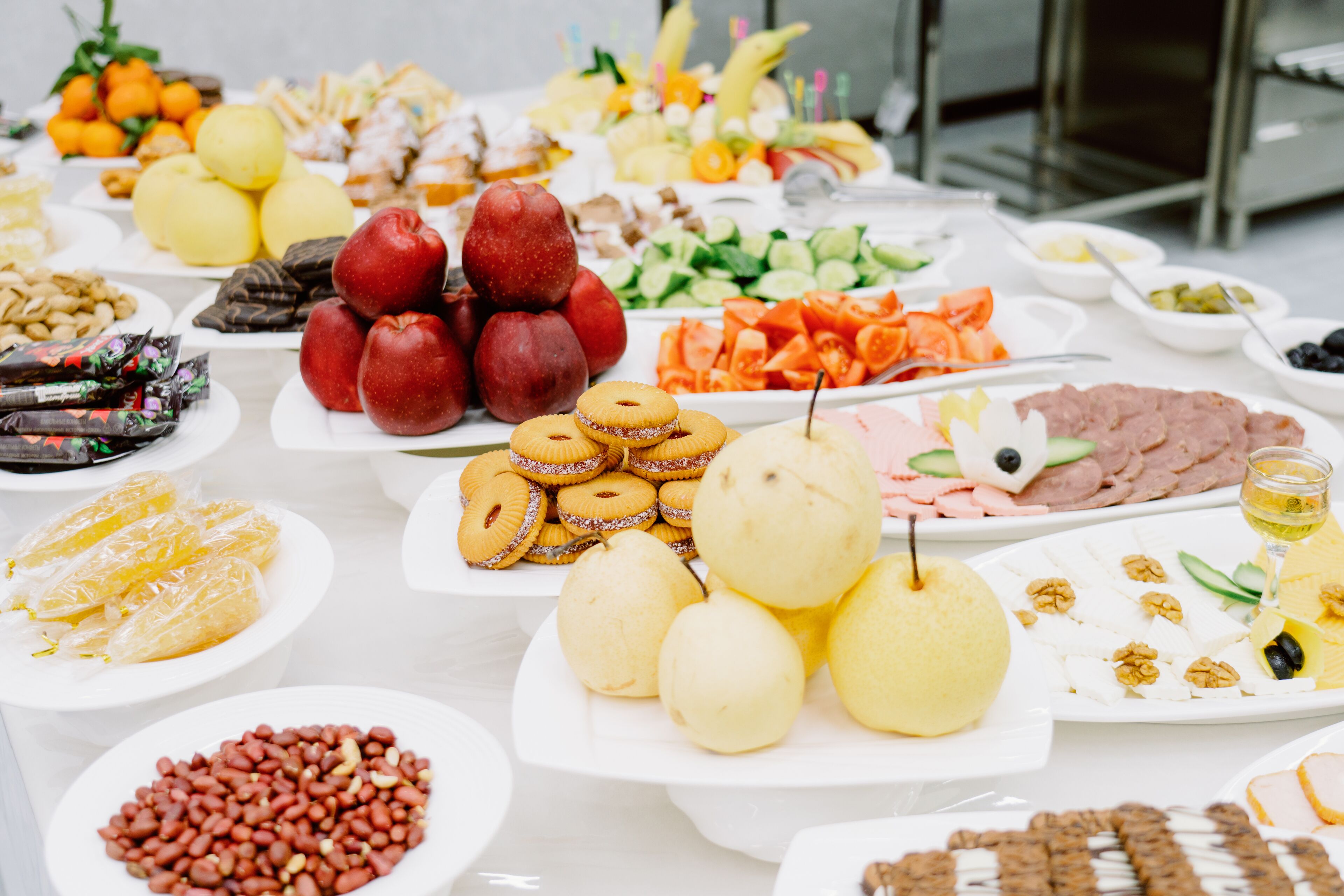 A buffet table with various food items including fruits, vegetables, and pastries.