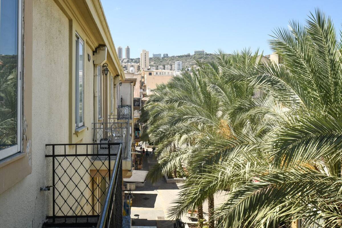 A balcony with a view of a cityscape and palm trees.