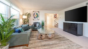 A modern living room with a sofa, coffee table, and a flat-screen TV.