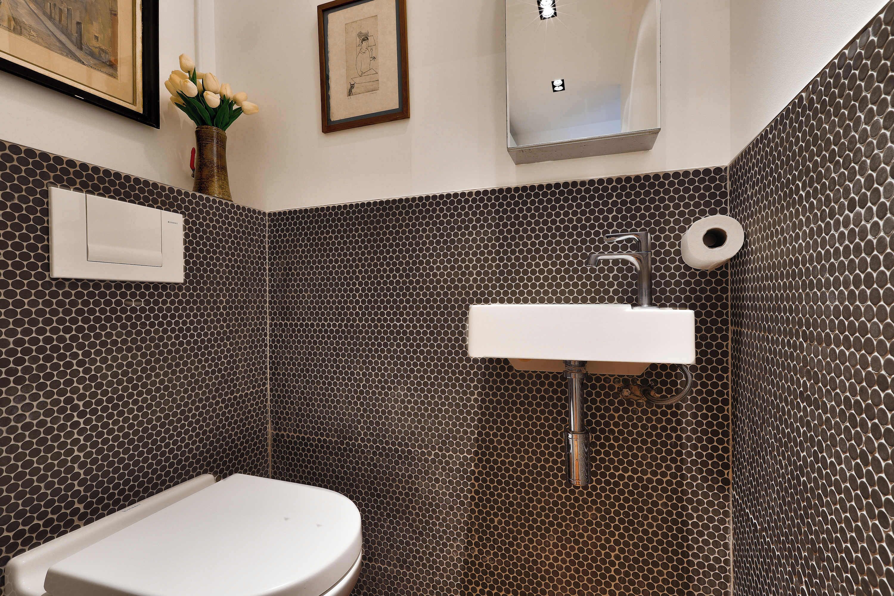 Un baño con inodoro, lavamanos y paredes con diseño.