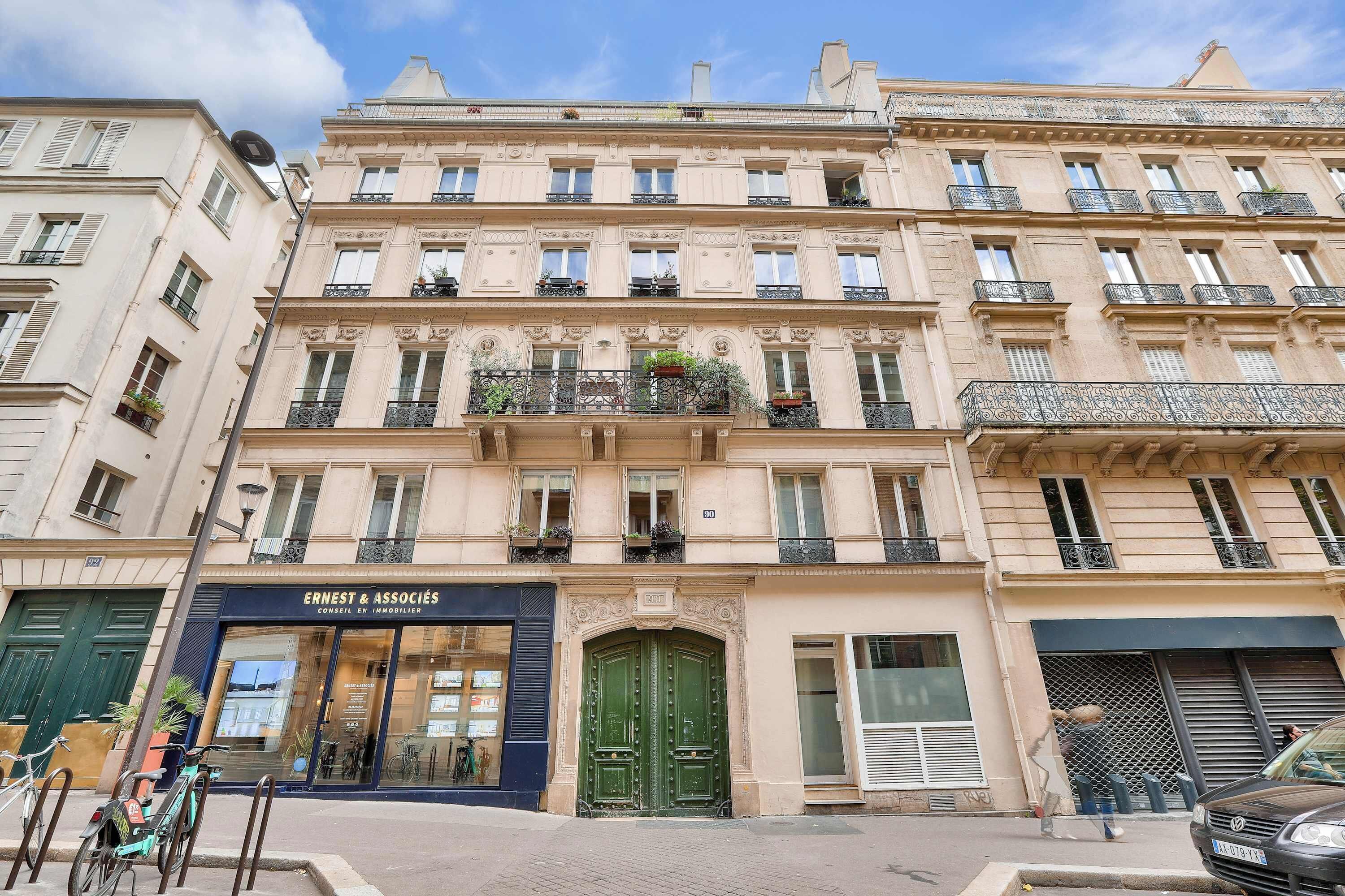 Un immeuble à plusieurs étages abritant un hôtel-boutique appelé « Ernest & Associates » au rez-de-chaussée.
