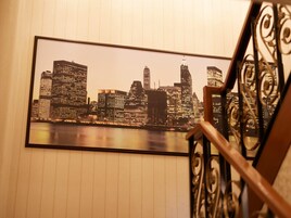 A framed cityscape photograph on a wall with a staircase in the foreground.