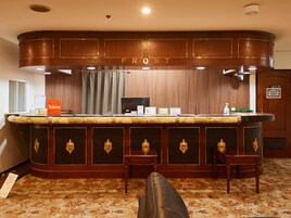 A reception area with a marble counter, a 'Front' sign, a 'Staff Only' sign, a 'Tabist' dispenser, and a 'Private' sign.