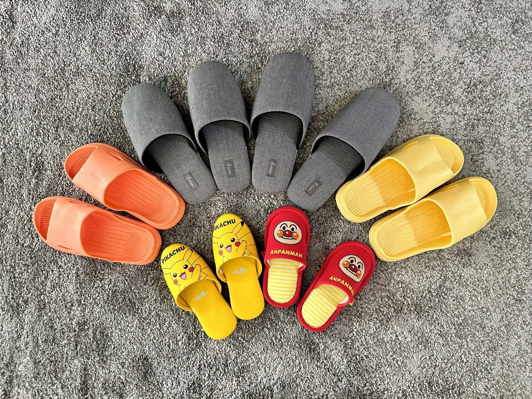 A variety of slippers arranged on a textured surface.
