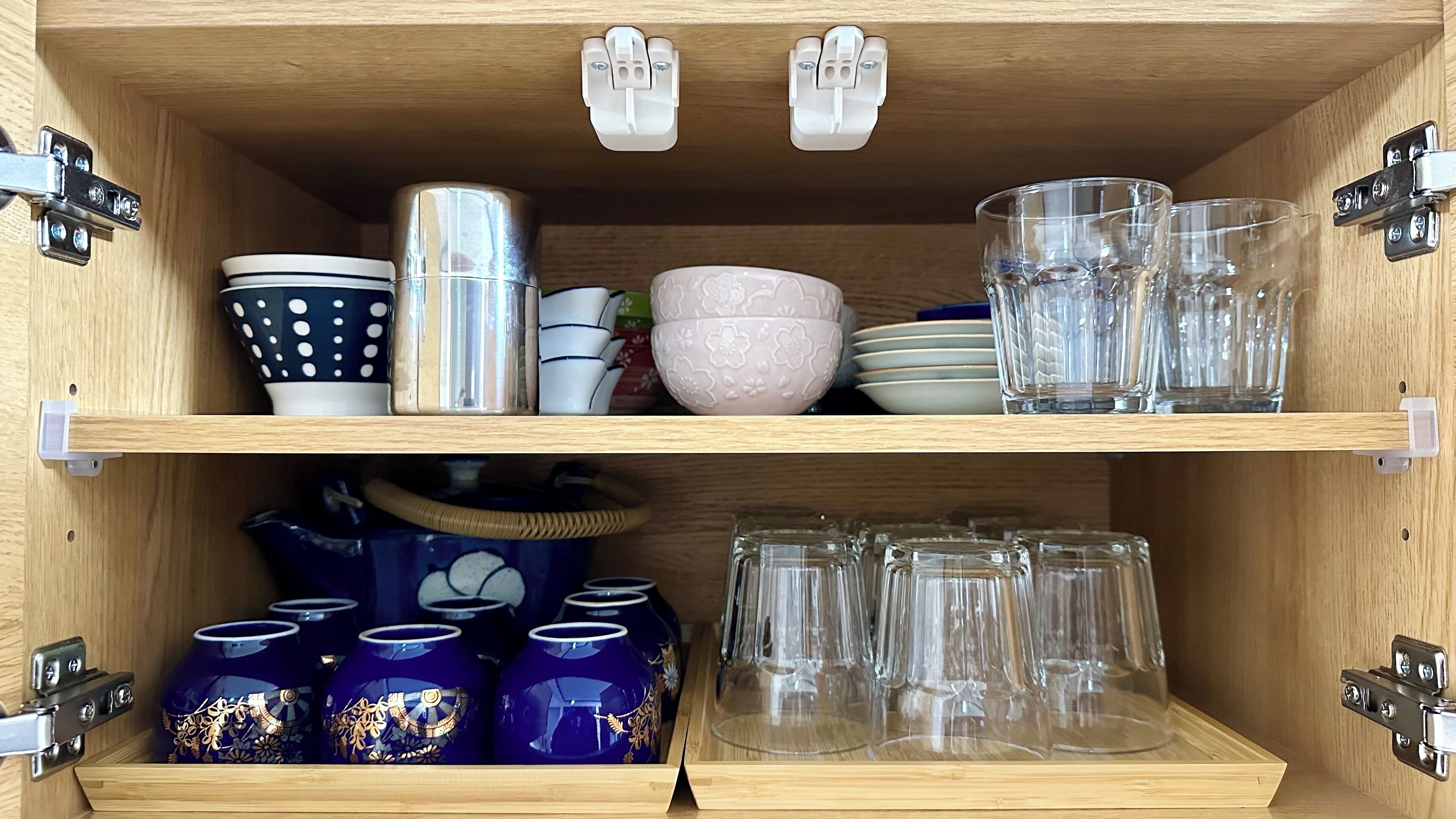 A wooden cabinet with shelves holding various kitchenware items.