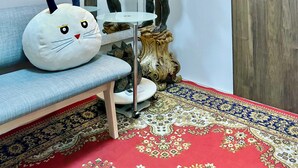 A room with a mirror, a white cat-shaped cushion, a small table, and a patterned carpet. - 5-minute walk from Dotonbori and Kuromon Market, a famous sightseeing spot!  (大阪市)