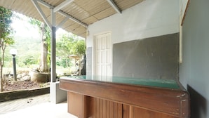 A wooden bench with a glass top, a white door, and a concrete wall. - SPOT ON 93620 Anisa Homestay Syariah Near Pantai Gemah Tulungaggung (Tulungagung)