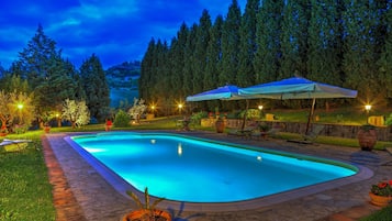 Relax by the pool surrounded by lush greenery and comfortable lounge chairs.