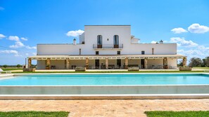 A large white building with a pool in front.