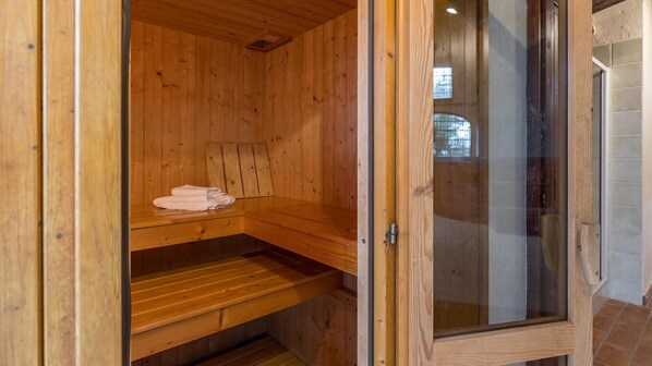 A wooden sauna with a bench and a towel on the shelf.