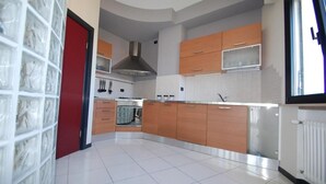A modern kitchen with wooden cabinets, a stainless steel range hood, and a tiled backsplash. - Bamb in Panoramica (Cattolica)