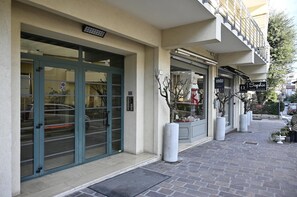 A building with a glass door entrance, a boutique sign, and a potted plant. - Bamb in Panoramica (Cattolica)