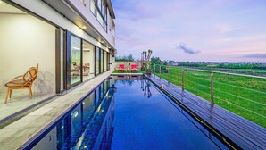 Ein modernes Hotel mit einem Dachpool, Sitzgelegenheiten im Freien und Blick auf die umliegende Landschaft.