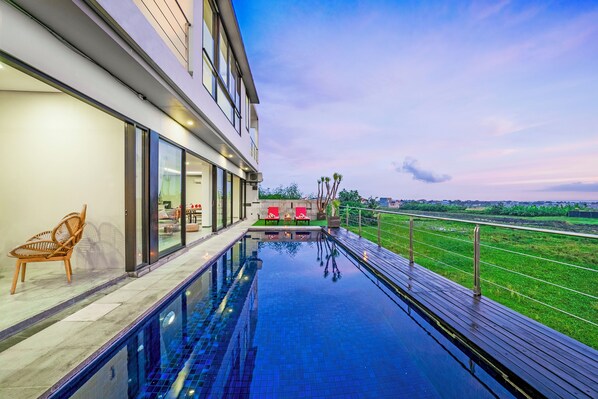 Un hôtel moderne doté d’une piscine à débordement sur le toit, d’un espace extérieur aménagé et offrant une vue sur le paysage environnant.