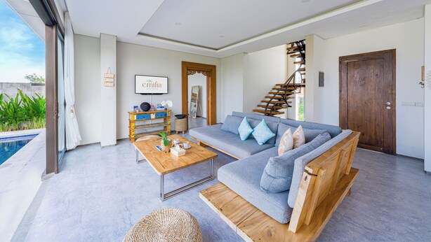 Ein modernes Wohnzimmer mit Sofa, Couchtisch und Treppe.