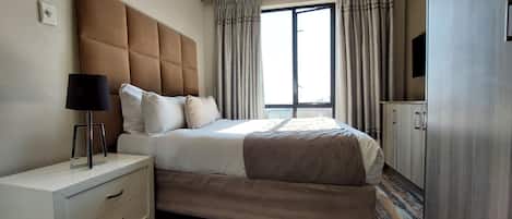 Premium bedding, Select Comfort beds, laptop workspace, blackout drapes