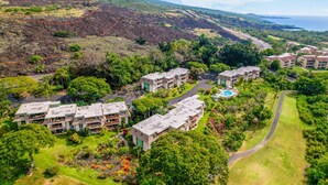 A resort with multiple buildings, a swimming pool, and lush greenery. - Ocean View Kona Condo | Relax, Unwind & Enjoy Island Life (Kailua-Kona)