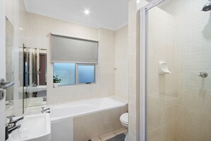 Un baño moderno con bañera, lavamanos e inodoro.