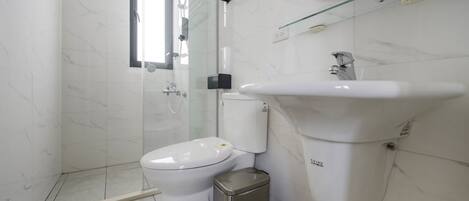 A modern bathroom with a toilet, bidet, and sink.