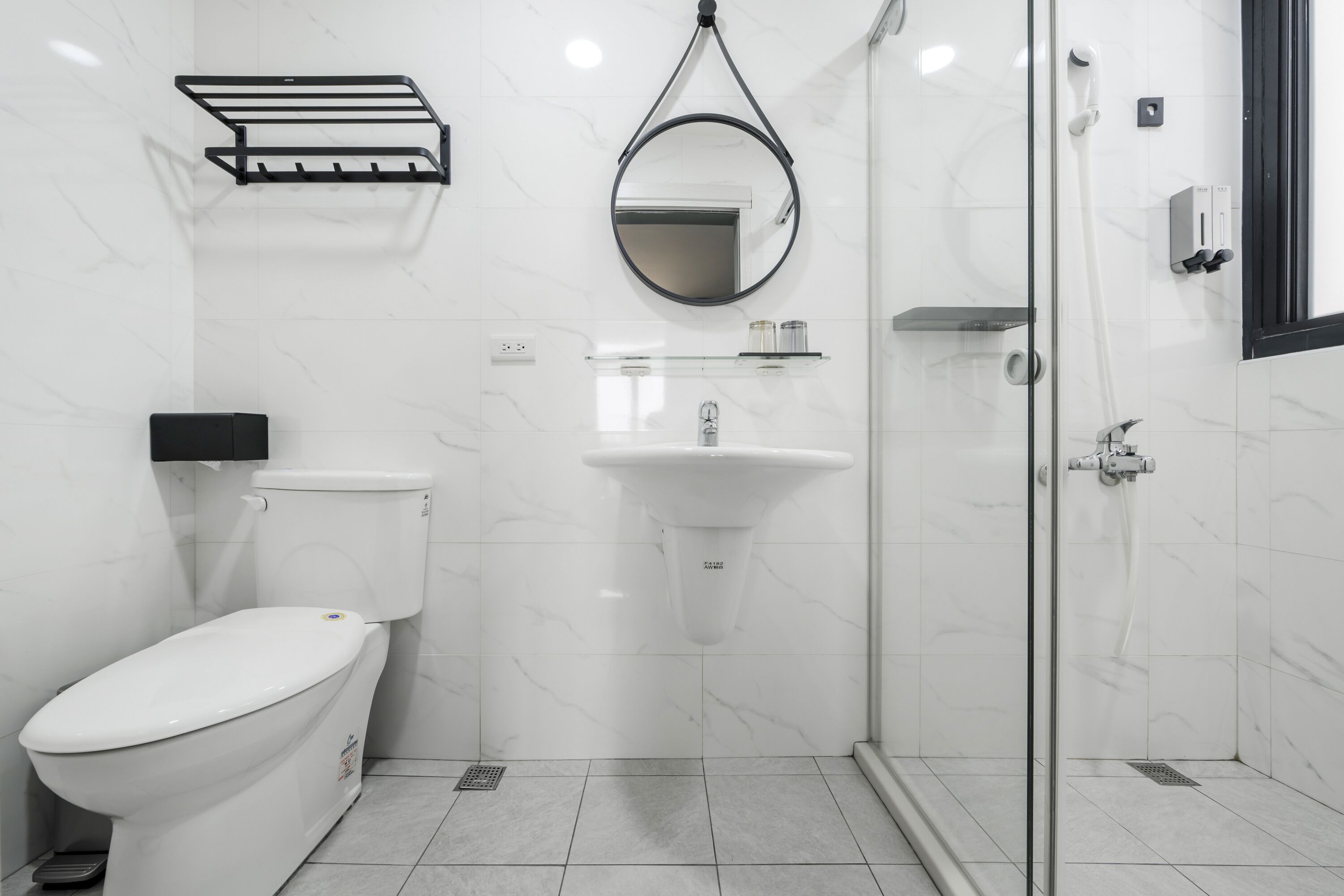 Een moderne badkamer met toilet, wastafel en douchecabine van glas.