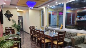 Un comedor con una mesa larga y sillas, un sofá y una mesa de centro con un cuenco decorativo.