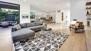 A modern living room with a sectional sofa, a coffee table, and a patterned rug. - LA Villa by AvantStay | Walk to The Grove LA (Los Angeles)