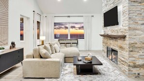A modern living room with a sofa, coffee table, and fireplace. - Castlewood by AvantStay | Malibu Cliffside + View (Malibu)