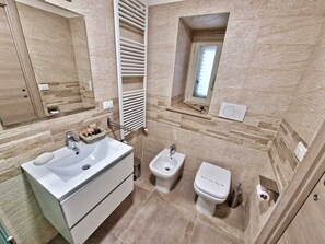 Een douche, een haardroger, een bidet, handdoeken