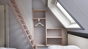 A bedroom with a skylight, a wooden ladder, and built-in shelving. - Bungalow near De Alde Feanen Reserve (Earnewald)
