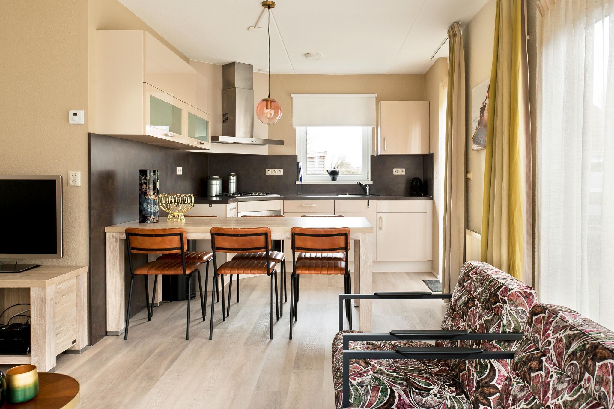 Una cocina moderna con comedor, sofá y televisor.