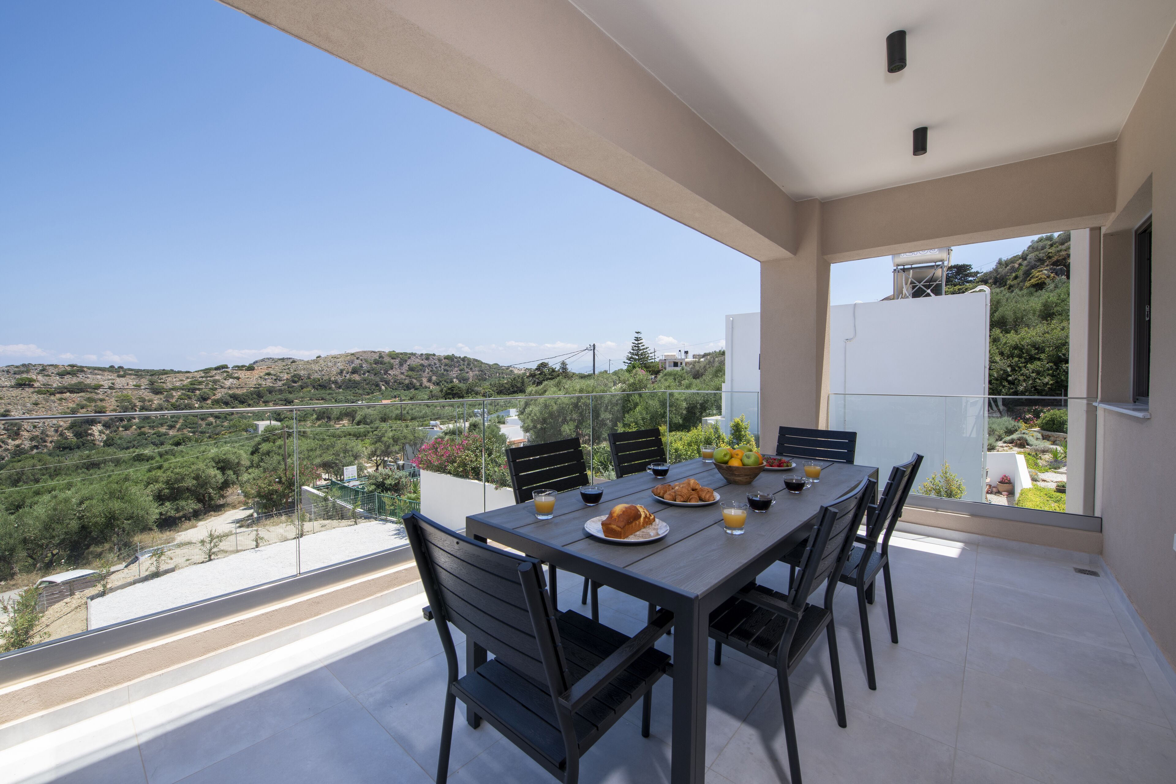 A dining area with a table set for two, overlooking a scenic landscape.