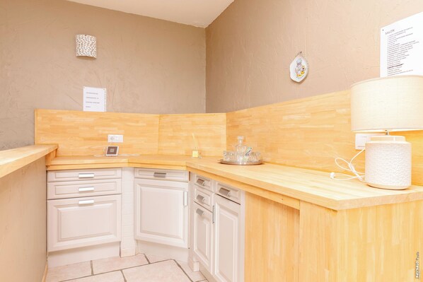 A kitchen with wooden countertops, white cabinets, a coffee machine, and a paper towel dispenser. - Villa Larmes - Swimming pool - SPA (Puybegon)