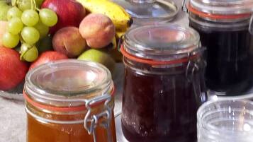 Ein Frühstücksbuffet mit verschiedenen Früchten und Gläsern mit Marmelade.
