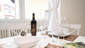 A dining table set with a wine bottle, wine glasses, plates, and cutlery. - La Torretta (Moniga del Garda)