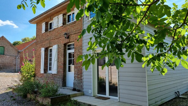 A two-story brick building with white shutters, a front door, and a sliding glass door. - Charming little gîte in the heart of the Baie de Somme (Saigneville)