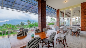 Un restaurant doté d’une terrasse offrant une vue panoramique, avec une table en bois et des chaises à motifs.