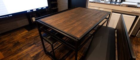 Una cocina moderna con una mesa de madera, un banco y un horno empotrado.