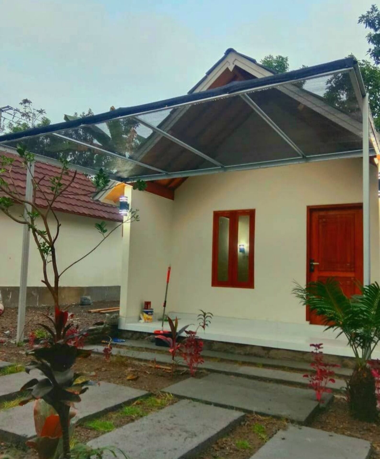 A house with a red door, a small window, and a covered porch area.