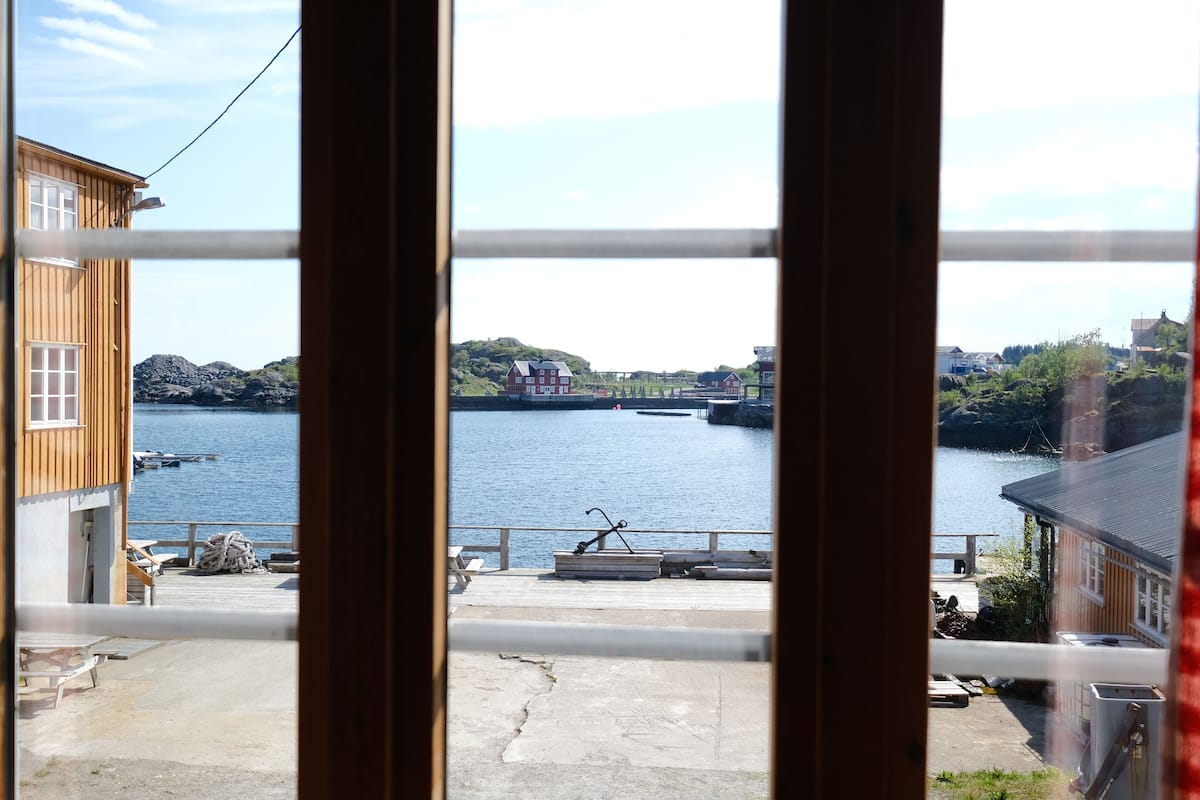 A wooden building with a dock and a view of a calm body of water.