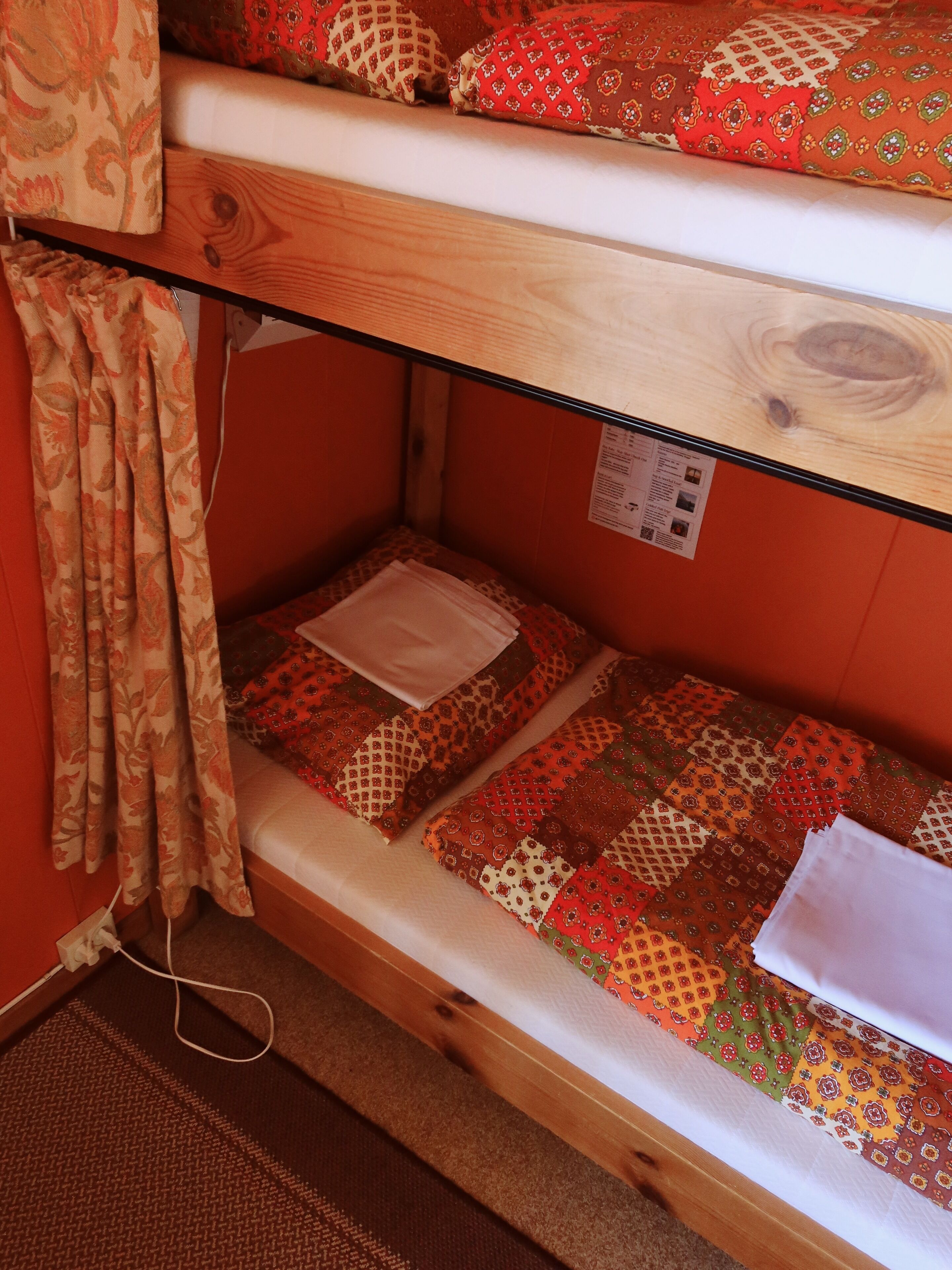 A bunk bed with patterned bedding and a wooden headboard.