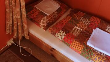 A bunk bed with patterned bedding and a wooden headboard.