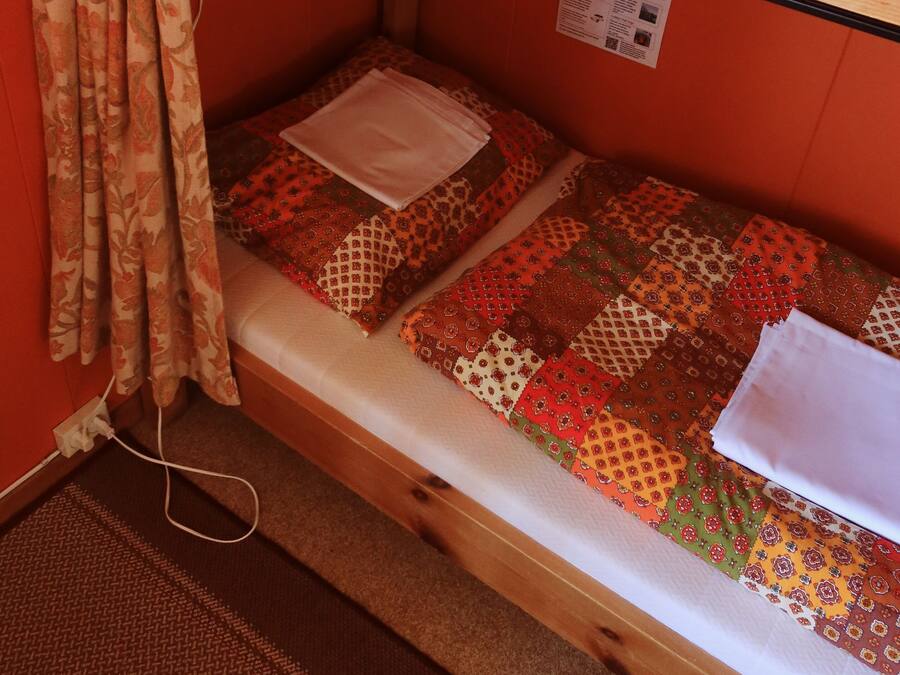 A bunk bed with patterned bedding and a wooden headboard.