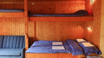 Una cabaña con una cama litera, un sofá y una pequeña mesa.