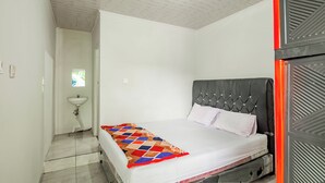 A bedroom with a bed, a window, a sink, and a door. - Hotel O Wongso Residence Syariah (Pangkalpinang)