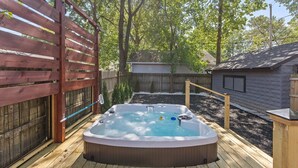 A hot tub on a wooden deck with a wooden fence and a shed in the background. - Beautiful Broad Ripple House (Indianapolis)