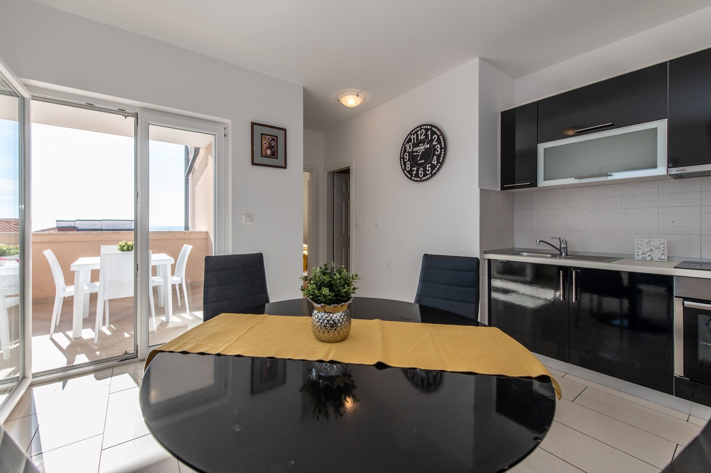 A modern kitchen with black cabinets, a microwave, and a sink.